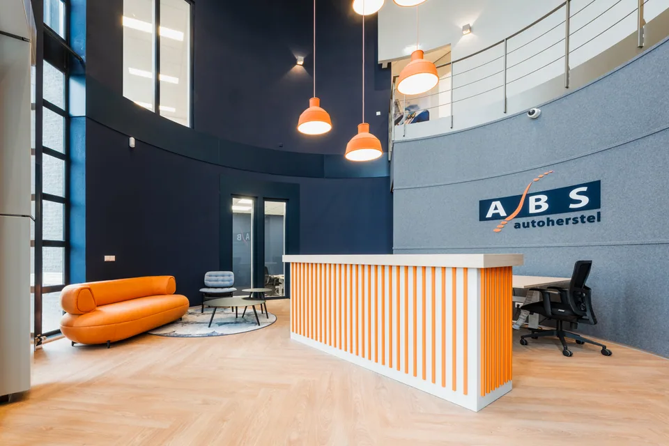 De vernieuwde entree met trap en hoge ruimte bij ABS Autoherstel