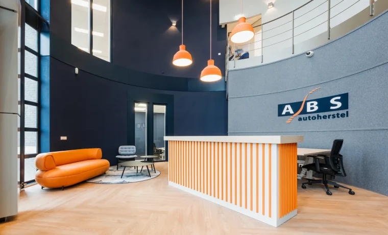 De vernieuwde entree met trap en hoge ruimte bij ABS Autoherstel